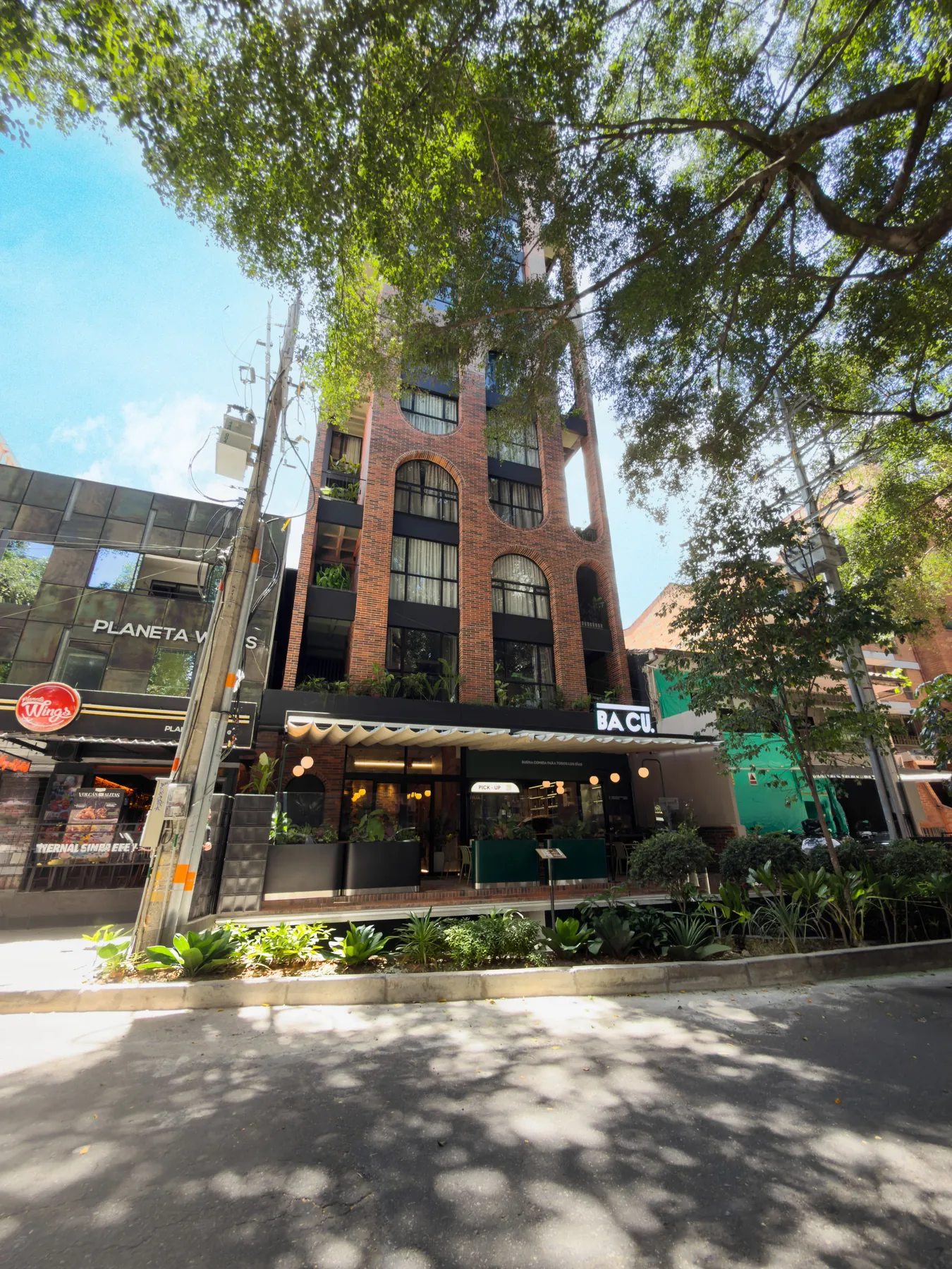 Fachada de URBIT Garden entre árboles en Laureles, Medellín